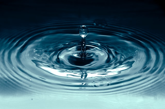 Una gota de agua cayendo sobre un estanque